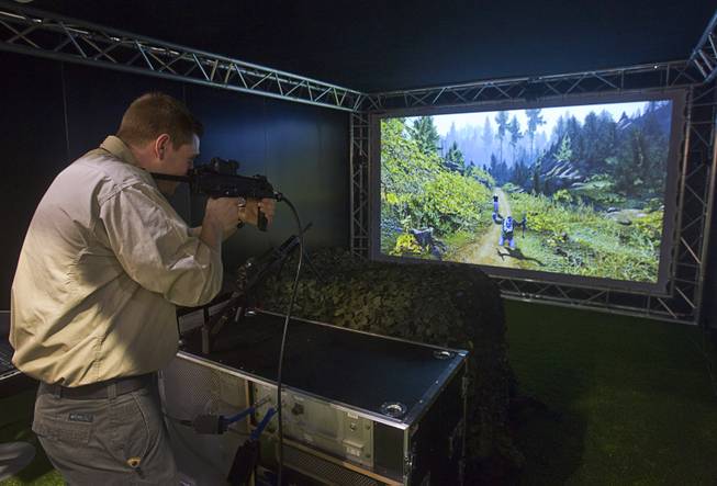 Mark Schneider of Maryland tries out a the Thales Saggitarius Evolution, a tactical small arms training simulator, during the 2014 SHOT Show (Shooting, Hunting, Outdoor Trade) at the Sands Expo & Convention Center Tuesday, Jan. 14, 2014. The French company markets the trainer to military and law enforcement agencies, a representative said.