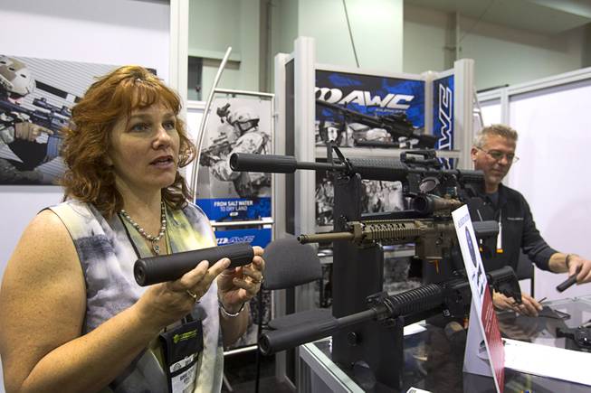 Bonnie DiCarlo explains the features of an AWC silencer to an attendee (not pictured) during the 2014 SHOT Show (Shooting, Hunting, Outdoor Trade) at the Sands Expo & Convention Center Tuesday, Jan. 14, 2014. Despite their military and Hollywood hitman reputations, silencers are often used by civilians to reduce recoil and noise, a representative said.