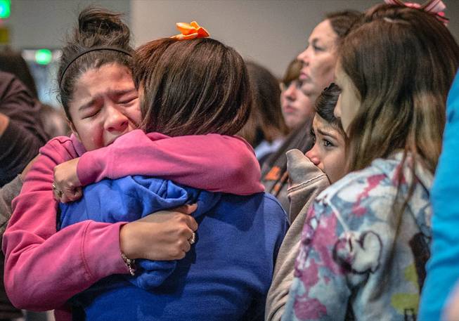 Thirteen-year-old Kimberly Macias cries as she sees schoolmates at a vigil for the victims, Tuesday, Jan. 14, 2014, in Roswell, N.M. 
