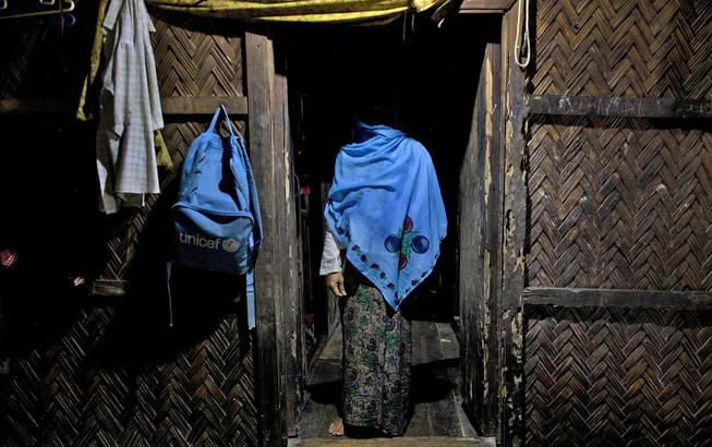 In this Sept. 15, 2013, photo, a woman who claims she was raped by Myanmar security forces stands in her home in Ba Gong Nar village, Maungdaw, northern Rakhine state, Myanmar. 
