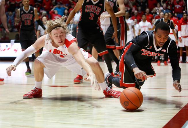 New Mexico's Hugh Greenwood, left, and UNLV's Deshawn Delaney hit the floor for a loose ball in the second half of an NCAA college basketball game Wednesday, Jan. 15, 2014 in Albuquerque, N.M. UNLV won 76-73.