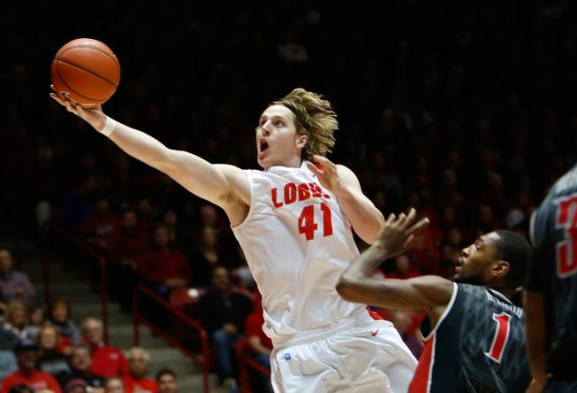 New Mexico's Cameron Bairstow scores under the basket in front of UNLV's Roscoe Smith in the first half of an NCAA college basketball game on Wednesday, Jan. 15, 2014, in Albuquerque.