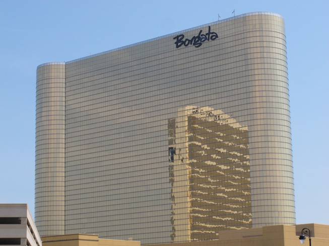 In this June 26, 2013, photo, the Borgata Hotel Casino & Spa is seen in Atlantic City, N.J., with the nearby Water Club reflected in its gold glass facade.