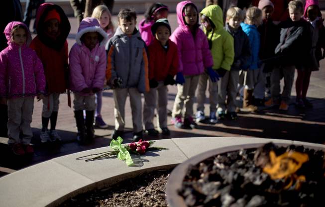 Roses sit in front of the eternal flame at the gravesite of Rev. Martin Luther King Jr., as kindergarten students with the Charles R. Drew Charter School pay a visit, Friday, Jan. 17, 2014, in Atlanta. The national Dr. Martin Luther King Jr. federal holiday this year is Monday, Jan. 20, five days after the civil rights leader would have turned 85-years-old. 