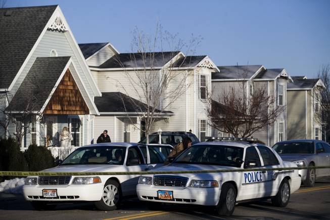 Police gather outside a home, Friday, Jan. 17, 2014, in Spanish Fork, Utah where five people were found dead on Thursday. A 34-year-old officer shot and killed his wife, mother-in-law and two young children and turned the gun on himself, authorities said Friday.