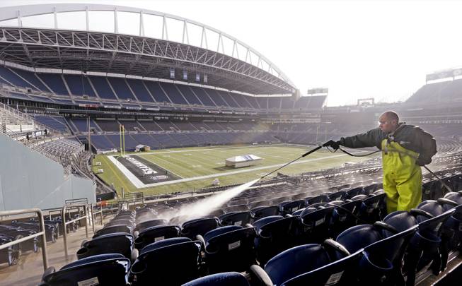 A worker cleans seats at CenturyLink Field on Wednesday, Jan. 15, 2014, in preparation for the NFL football NFC championship game Sunday in Seattle. 
