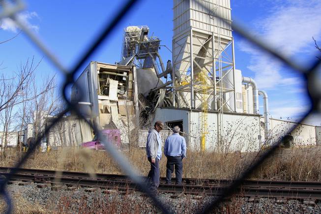 Two unidentified people with ties to the International Nutrition plant in Omaha, Neb., stand Monday, Jan. 20, 2014, outside the plant where a fire and explosion took place .
