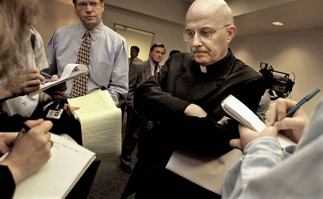 This April 17, 2002, file photo shows Chicago Cardinal Francis George listening to reporters' questions before he left for Rome to meet with Vatican officials and other American cardinals about the child sex abuse scandals in the United States.
