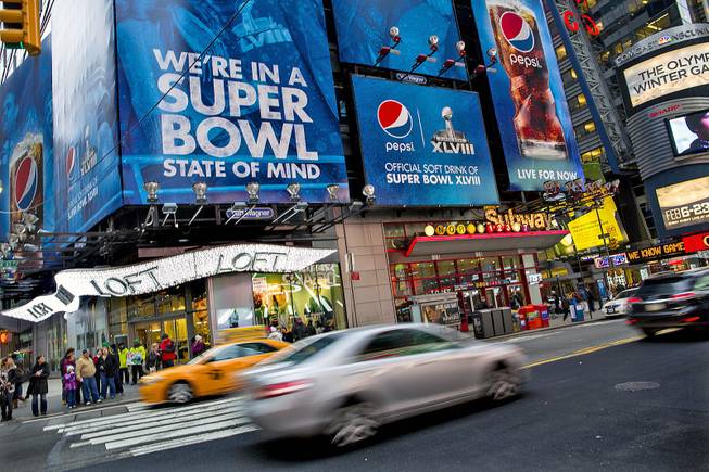 Large signs advertising the Super Bowl are seen on 42nd Street by Times Square, Monday, Jan. 20, 2014, in New York.