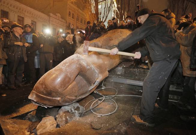 Ukrainian protesters smash a statue of Vladimir Lenin with a sledgehammer after toppling it, in central Kiev, Ukraine, Sunday, Dec. 8, 2013. The third week of protests continue Sunday with an estimated 200,000 Ukrainians occupying central Kiev to denounce President Viktor Yanukovychs decision to turn away from Europe and align this ex-Soviet republic with Russia. 