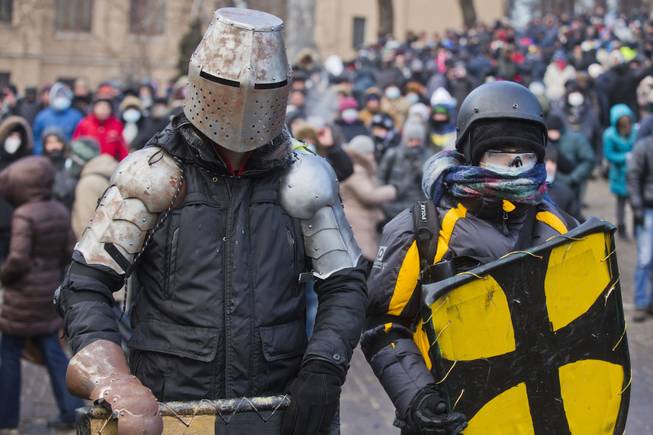 Protesters clad in improvised protective gear prepare for a clash with police in central Kiev, Ukraine, Monday, Jan. 20, 2014. After a night of vicious streets battles, anti-government protesters and police clashed anew Monday in the Ukrainian capital Kiev. 