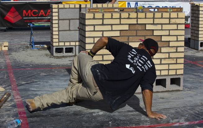 Jimmy Quinteros of Sarasota, Fl., gets low to inspect his work in the "Masonry Skills Challenge" competition as a third year apprentice during the 40th anniversary of the World Of Concrete event on Wednesday, Jan. 22, 2014.