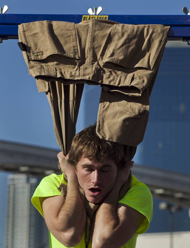 Robert Helfrich of Gahanna, Ohio, hangs from a pair of Blaklader pants during at contest during the 40th anniversary of the World Of Concrete at the Las Vegas Convention Center on Wednesday, Jan. 22, 2014.