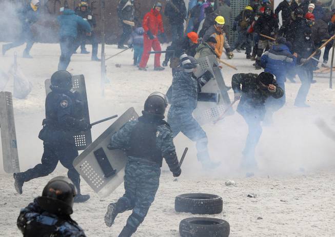 A police officer beats a protester during clashes in central Kiev, Ukraine, Wednesday, Jan. 22, 2014. Police in Ukraineis capital on Wednesday tore down protester barricades and chased demonstrators away from the site of violent clashes, hours after two protesters died after being shot, the first violent deaths in protests that are likely to drastically escalate the political crisis that has gripped Ukraine since late November. 