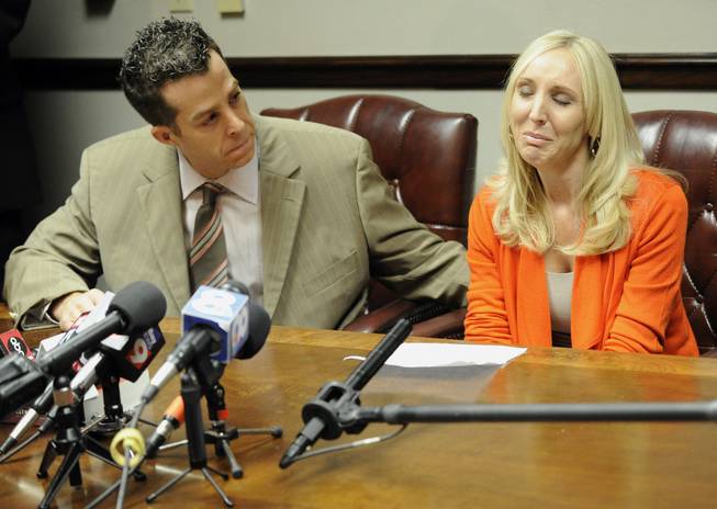 Nicole Oulson, the widow of Chad Oulson who was shot and killed over a texting dispute at a Wesley Chapel movie theater this month, is consoled by attorney T.J. Grimaldi as she speaks to reporters Wednesday, Jan. 22, 2014, in Tampa, Fla. Oulson became emotional as she read a statement saying her life was “shattered into a million pieces.”