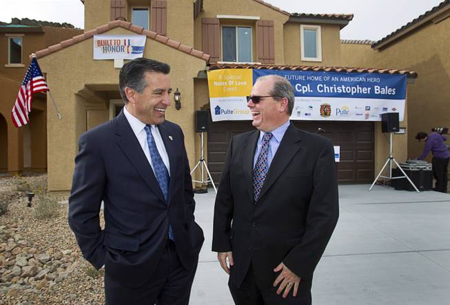 Nevada Governor Brian Sandoval, left, and Scott Wright, Pulte Group division president, chat before a new home dedication for Army Sgt. Christopher Bales and his family at the Coldwater Crossing subdivision in the Mountain's Edge master planned community Thursday Jan. 23, 2014. Pulte Homes, along with other companies, presented the home to Bales as part of Operation Finally Home," an organization which provides homes to veterans and the families of fallen servicemen.