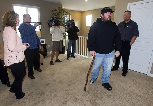 Army Sgt. Christopher Bales and family members get a look at the inside of his new home at the Coldwater Crossing subdivision in the Mountain's Edge master planned community Thursday Jan. 23, 2014. Bales was shocked to discover that the home was completely furnished. Pulte Homes, along with other companies, presented the home to Bales as part of Operation Finally Home," an organization which provides homes to veterans and the families of fallen servicemen.