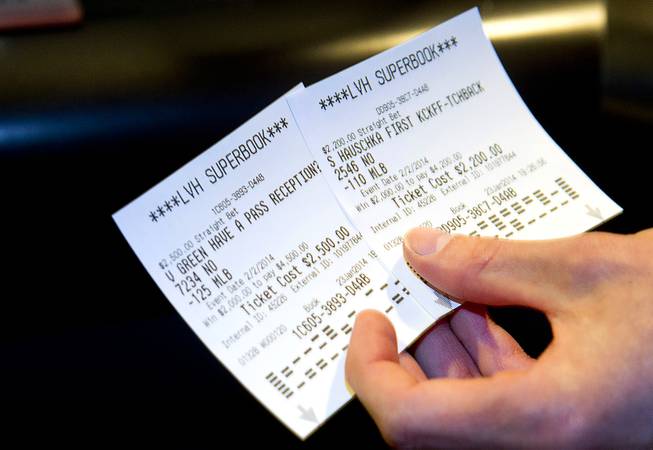 A gambler displays his betting slips after Super Bowl XLVIII proposition bets were posted at the Las Vegas Hotel Superbook Thursday Jan. 23, 2014.