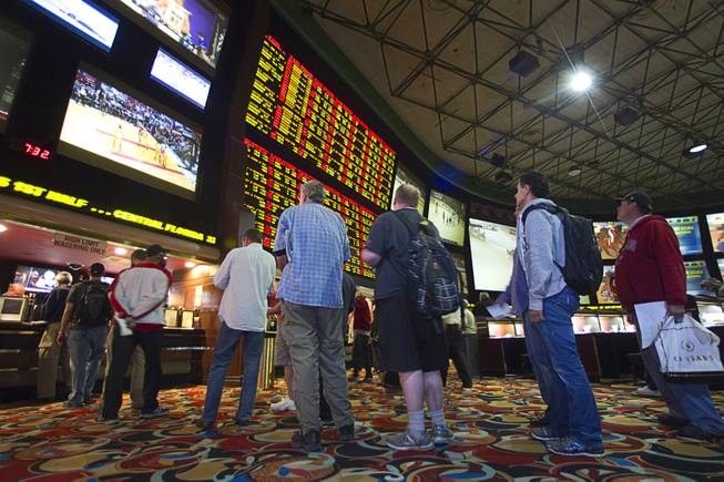 Gamblers wait in line to place bets after Super Bowl XLVIII proposition bets were posted at the Las Vegas Hotel Superbook Thursday Jan. 23, 2014.