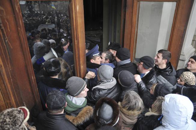 Protesters break into the building of the regional governor's office in Lviv, Western Ukraine, Thursday Jan. 23, 2014. Tensions in Ukraine spread far from its embattled capital on Thursday as hundreds of people in the city of Lviv stormed into the regional governor's office and forced him to write a letter of resignation. 