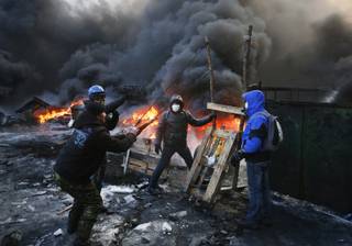 Protesters use a large slingshot to hurl rocks at police in central Kiev, Ukraine, Thursday Jan. 23, 2014. Thick black smoke from burning tires engulfed parts of downtown Kiev as an ultimatum issued by the opposition to the president to call early election or face street rage was set to expire with no sign of a compromise on Thursday. (AP Photo/Sergei Grits)