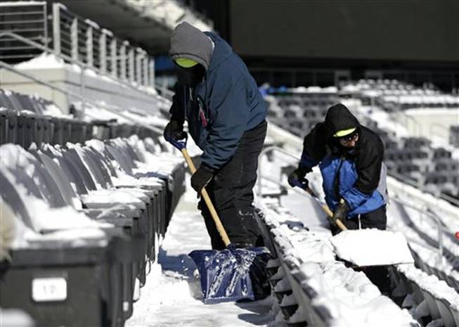 Workers shovel snow off the seates at MetLife Stadium as crews removed snow ahead of Super Bowl XLVIII following a snow storm, Wednesday, Jan. 22, 2014, in East Rutherford, N.J. Super Bowl XLVIII, which will be played between the Denver Broncos and the Seattle Seahawks on Feb. 2, will be the first NFL title game held outdoors in a city where it snows.