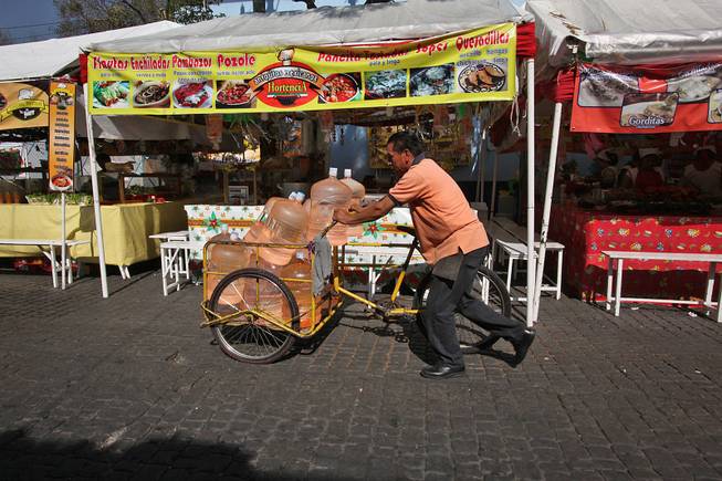 A vendor pushes his bicycle cart filled with 18-liter jugs of bottled water to sell to owners of street food stalls in Mexico City,  Jan. 4, 2014. Bad tap water accounts in part for Mexico being the highest consumer of bottled water and sweetened drinks. 