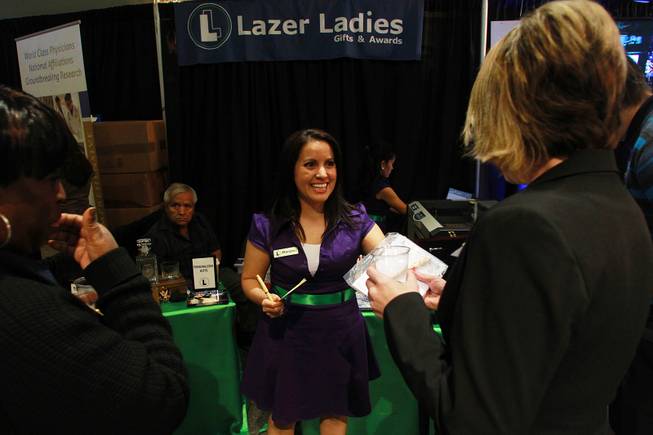 Marylou Soto, one of the owners of Lazer Ladies Gifts & Awards, hands out custom engraved pens during the Las Vegas Metro Chamber of Commerce "Preview Las Vegas" event Friday, Jan. 24, 2014.