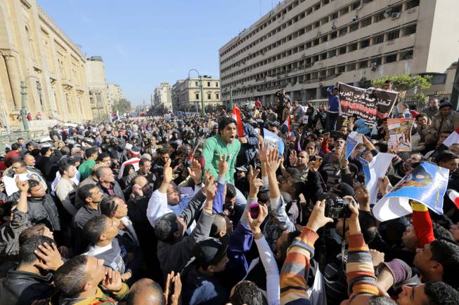 Egyptians shout anti-terrorism slogans as they demonstrate in front the site of a blast at the Egyptian police headquarters, at right, and the Museum of Islamic Art, at left, in downtown Cairo, Egypt, Friday, Jan. 24, 2014. A car bomb struck the main Egyptian police headquarters Friday in the heart of Cairo, killing several people in a hugely symbolic attack on the eve of the third anniversary of the 2011 uprising that toppled longtime autocratic ruler Hosni Mubarak.