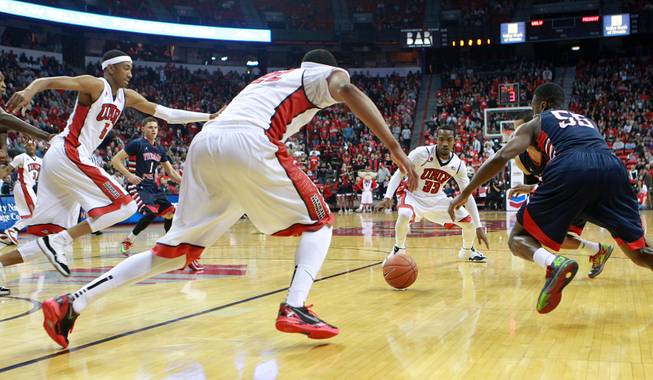 From left, UNLV's Chris Wood, Jelan Kendrick and Deville Smith and Fresno St. guard Allen Huddleston converge on a loose ball during their game Saturday, Jan. 25, 2014 at the Thomas & Mack Center.