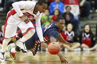 UNLV guard Deville Smith and Fresno St. guard Marvelle Harris chase down a loose ball during their game Saturday, Jan. 25, 2014 at the Thomas & Mack Center. UNLV won 75-73 in overtime.