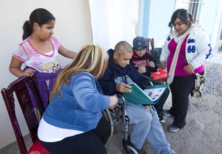 Francisco Diaz, center, looks over a photo album with family members in Mexicali, Mexico Saturday, Jan. 25, 2014. Diaz was born in Mexico but grew up in Las Vegas with a green card.