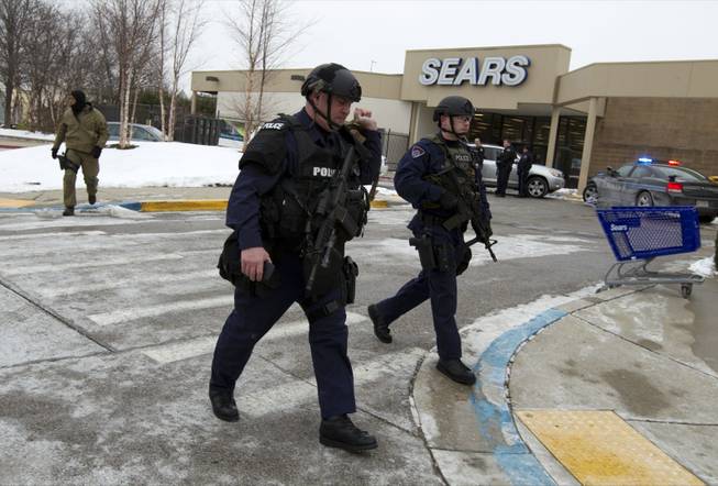 Police move in from a parking lot to the Mall in Columbia after reports of a multiple shooting Saturday Jan. 25, 2014, in Howard County, Md. 