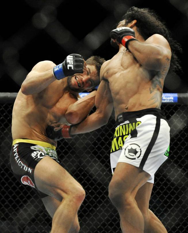 Benson Henderson, right, punches Josh Thomson during the main event of a UFC mixed martial arts match in Chicago on Saturday, Jan. 25, 2014.