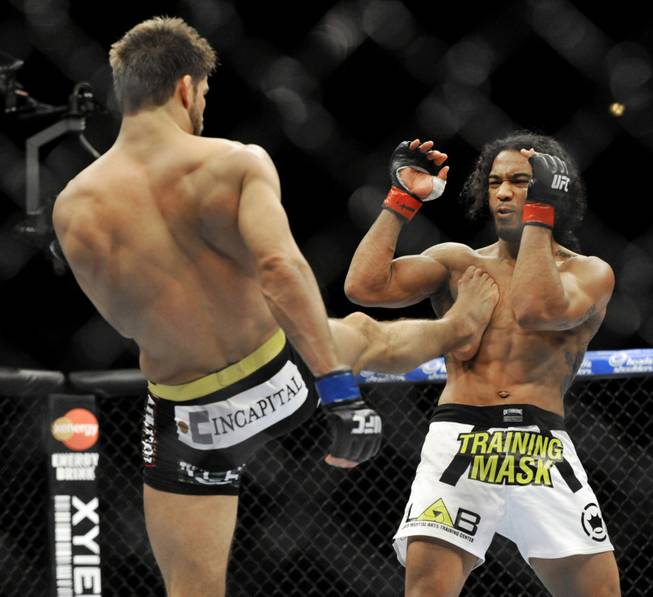 Josh Thomson, left, kicks Benson Henderson during the main event of the UFC mixed martial arts event in Chicago, Saturday, Jan., 25, 2014.