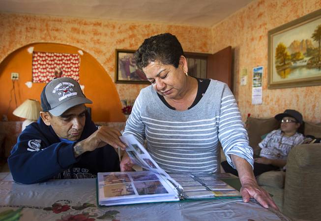 Francisco Diaz looks over a photo album with his mother Adela Espana in Mexicali, Mexico Sunday, Jan. 26, 2014. Diaz was born in Mexico but grew up in Las Vegas with a green card. Diaz was beaten and robbed after he was deported to Mexicali.