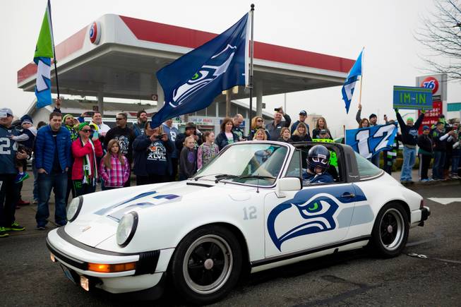 Kel Klink, in his vinyl-wrapped 1978 Porsche 911, rallies alongside thousands of diehard 12thMan fans who lined South 188th Street to see off the Seahawks team buses on their way to the airport en route to New York for Super Bowl XLVIII, Sunday, Jan. 26, 2014, in SeaTac, Wash.