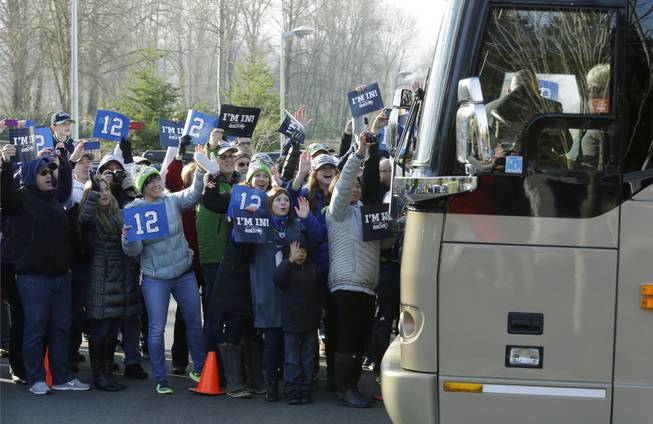 Fans cheer as buses carrying Seattle Seahawks players and coaches leave team headquarters in Renton, Wash., Sunday, Jan. 26, 2014. The Seahawks were heading to the airport for their flight to play the Denver Broncos in the NFL Super Bowl XLVIII football game in East Rutherford, N.J. 