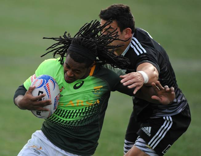 South African player Branco du Preez (left) evades the tackle of New Zealander Bryce Heem (right) on his way to a score during the Cup Final match of the USA 7's rugby tournament at Sam Boyd Stadium on Sunday afternoon. South Africa won the match 14-7.