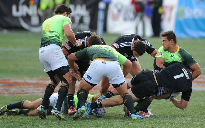 Players battle for control of a loose ball during the Cup Final match of the USA 7's rugby tournament at Sam Boyd Stadium on Sunday afternoon between South Africa and New Zealand. South Africa won the match 14-7.