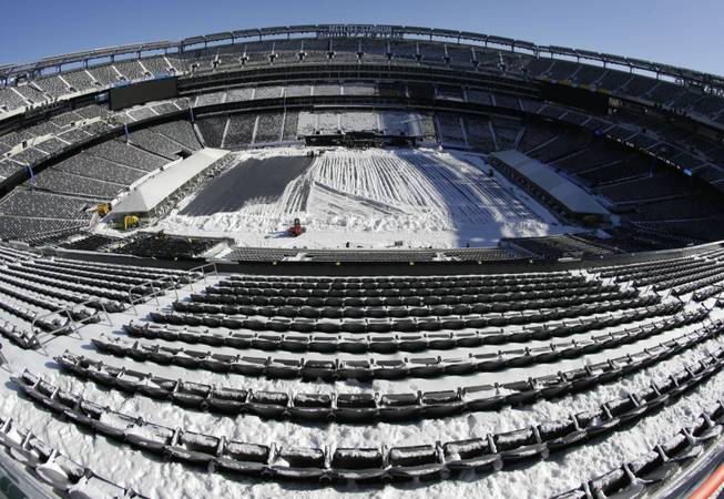 In this photograph taken with a fisheye lens, snow is accumulated on the seats and on the field of MetLife Stadium as crews removed snow ahead of Super Bowl 48 after a snow storm Wednesday, Jan. 22, 2014, in East Rutherford, N.J.