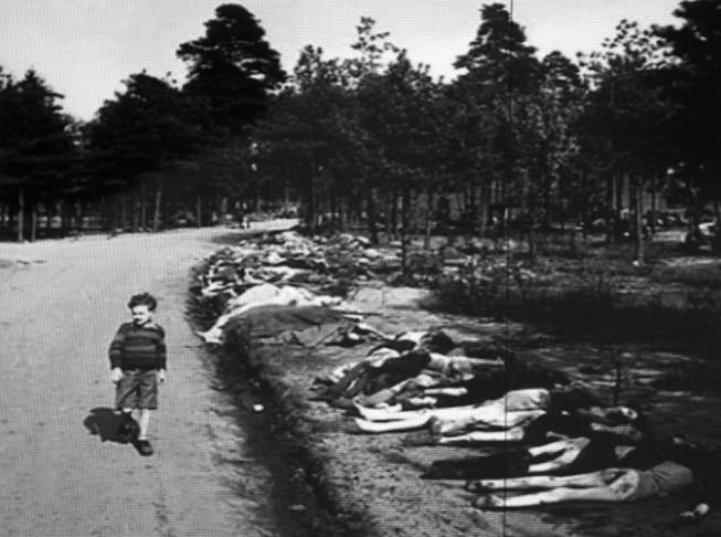 A photo of child passing by bodies at the Bergen-Belsen concentration camp is shown during a presentation by Ret. Major Leonard Berney speaks at Congregation Ner Tamid in Henderson Monday, Jan. 27, 2014. Berney was a member of British forces that liberated the concentration camp during Word War II. The presentation was part of International Holocaust Memorial Day.