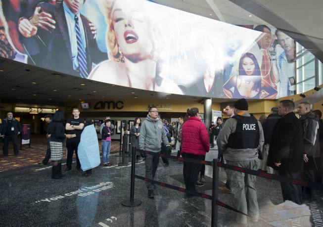 Mall visitors and law enforcement officers are gather at a lobby of a movie theater at The Mall in Columbia Saturday, Jan. 25, 2014, following a shooting in Columbia, Md.  Police say three people died at the mall including the presumed gunman.  
