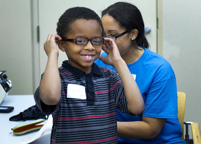 Michael Taylor, 8, a second grader at Duncan Elementary School, tries out eyeglasses at the Andre Agassi College Preparatory Academy Tuesday, Jan. 27, 2014. Over 100 Clark County School District students received free eye exams and new glasses from OneSight. OneSight is an organization providing access to eye care and eyewear to underserved communities.