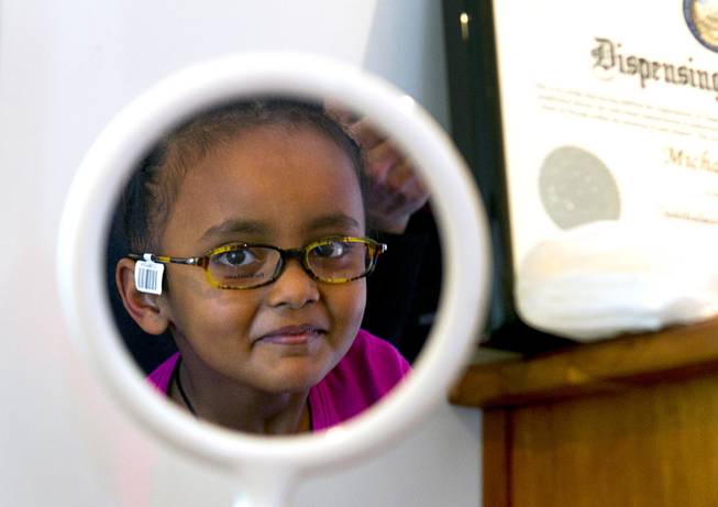 Loza Hailu, 6, a first grader at Hoggard Elementary School, looks in a mirror as she tries out frames in the OneSight mobile vision center at the Andre Agassi College Preparatory Academy Tuesday, Jan. 27, 2014. Over 100 Clark County School District students received free eye exams and new glasses. OneSight is an organization providing access to eye care and eyewear to underserved communities.