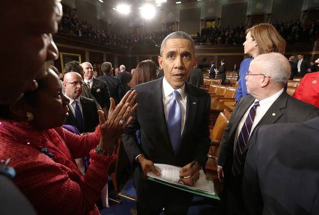 President Barack Obama signs autographs for members of Congress after giving the State of Union address before a joint session of Congress in the House chamber Tuesday, Jan. 28, 2014, in Washington, D.C.