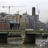 Construction cranes work on buildings in London on Friday, Jan. 24, 2014. 