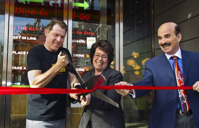Chef Bobby Flay cuts a ribbon with Clark County Commissioner Mary Beth Scow during the opening ceremony of his Bobby’s Burger Palace on Wednesday, Jan. 29, 2014, on the Strip in Las Vegas.