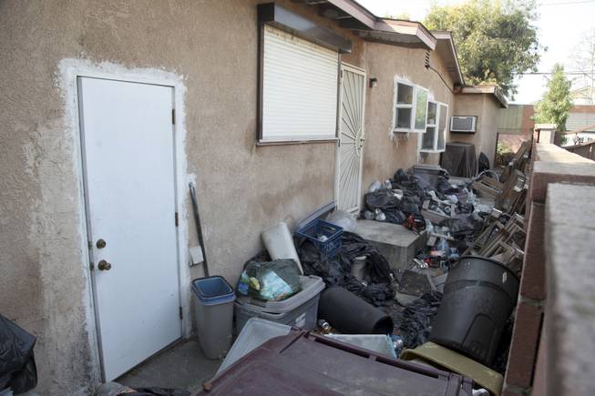 Trash is shown stacked against the home of William Buchman Wednesday Jan. 29, 2014 in Santa Ana, Calif. Buchman has  been arrested for investigation of neglect in the care of animals, after authorities found at least 300 living and dead pythons in plastic bins inside Buchman's stench-filled suburban home.