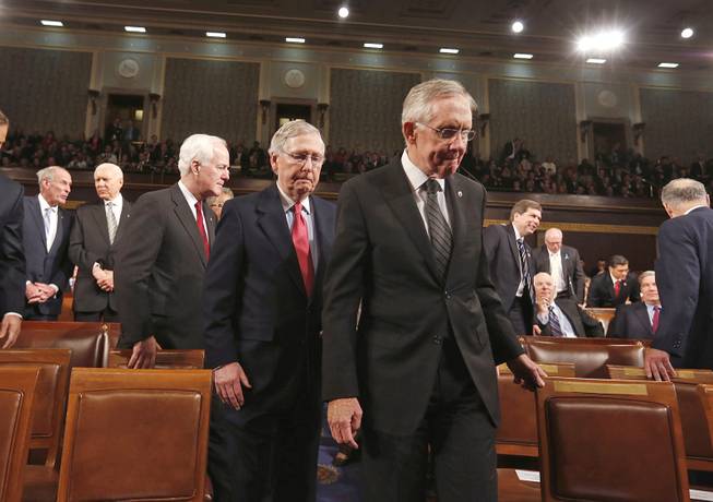 Senate Majority Leader Harry Reid leads Senate Minority Leader Mitch McConnell and Minority Whip John Cornyn to the front of the chamber before President Barack Obama delivers the State of Union address Tuesday, Jan. 28, 2014, before a joint session of Congress.